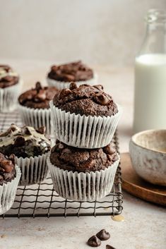 chocolate muffins on a cooling rack next to a glass of milk