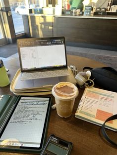 an open laptop computer sitting on top of a table next to a cup of coffee