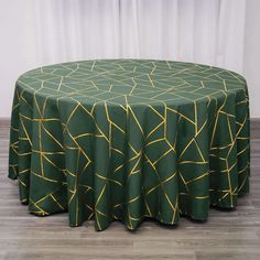 a green round table with gold lines on it and a white curtain in the background