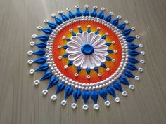 a colorful design on the floor with beads and bead work in blue, orange and white