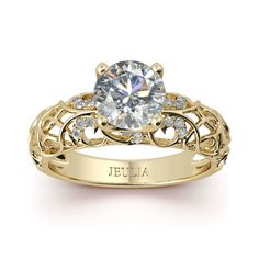 a yellow gold engagement ring with an intricate design and a round center stone surrounded by small diamonds