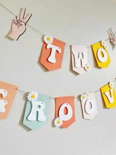 a banner with the word love hanging from it's sides and flowers on each side