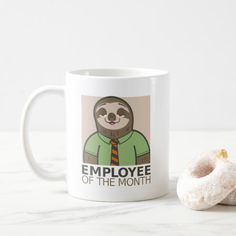 a coffee mug with a slotty on it next to a donut that says employee of the month