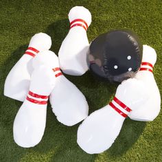 several bowling pins and a ball laying on the grass