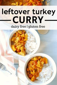 two bowls filled with curry and rice on top of a white table next to a fork