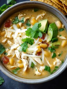 a bowl filled with chicken tortilla soup and garnished with cilantro