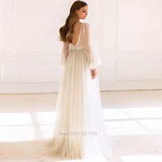 the back of a woman wearing a long white dress