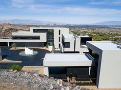 an aerial view of a modern house in the desert with mountains in the back ground