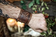 Leather cuff bracelet with the Three Horns of Odin, made of premium leather. The original design of Odin's horns is carefully embossed on the piece, which has been subjected to a handmade aging process identical to those used in Hollywood movies so that the piece seems directly drawn from an epic fantasy story. The size of the laced version ranges from 17 to 22 cm If your size varies from these measures please contact us before buying. The price is for a single bracer. Adjustable Viking Leather Bracelet, Handmade Viking Leather Bracelet For Gifts, Handmade Viking Leather Bracelet Gift, Adjustable Leather Viking Bracelet, Adjustable Viking Style Leather Bracelet, Handmade Viking Leather Bracelet, Horns Of Odin, Armor Ideas, Celtic Clothing