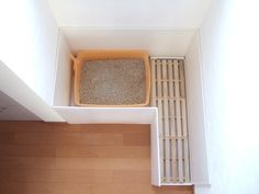 a cat litter box sitting on top of a wooden floor