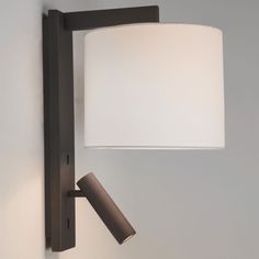 a wall light with a white shade on it