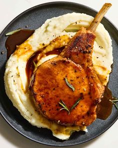 a black plate topped with mashed potatoes and meat