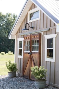 an outside view of a small shed with flowers in the potted planter next to it