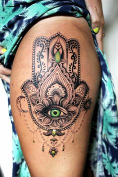 a woman's thigh with a hamsa tattoo on it