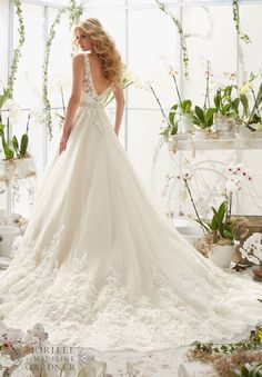 a woman in a wedding dress standing next to flowers