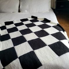 a black and white checkered blanket on top of a bed