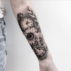 a woman's arm with a clock and sunflowers tattoo on the forearm