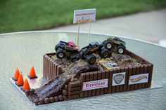 there is a cake made to look like a truck and some cars on top of it