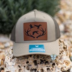 Add a touch of country charm to your wardrobe with our Antlers & Ducks Leather Patch trucker hat! Made with a durable Richardson 112 cap and featuring a stylish leather patch, this hat is perfect for any outdoor lover. Stay cool and look cool with this retro-inspired cap. The leather patch designs are affixed with adhesive for very secure attachment to the hat. Due to monitor colors, patches and hat colors may be slightly different in person. Custom leather patch hats are made from laser-engraved LEATHERETTE material.  THIS IS A PHYSICAL PRODUCT! Leather Patch Hat Design, Baseball Cap With Leather Patch, Outdoor Leather Patch Baseball Cap, Leather Patch Trucker Hat For Camping, Brown Leather Patch Hunting Hat, Waterproof Hat, Rhinestone Hoodie, Patriotic Outfit, Patch Design