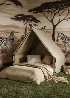 there is a tent bed with two zebras on the wall and grass in front of it