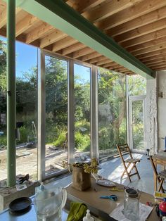 the inside of a house with lots of glass walls and windows on each side of the room