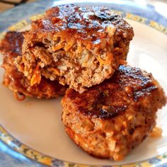 two meat patties sitting on top of a blue and white plate with orange flowers