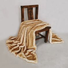 a chair with a blanket on top of it and a wooden frame in the middle