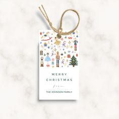 a merry christmas card hanging from a string on a marble background with an ornament