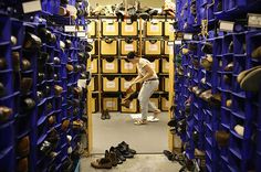 a woman is standing in the middle of a room full of shoes