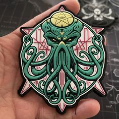 a hand holding an octopus sticker on top of a table