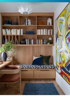 a room that has some bookshelves and a couch in it with a painting on the wall