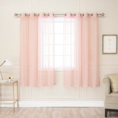 a living room with pink curtains and a chair