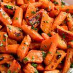 a plate full of cooked carrots with parsley on top