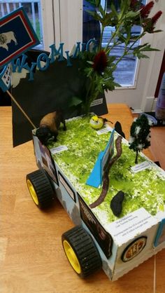 a cake made to look like a car with plants on the roof and wheels, sitting on a table