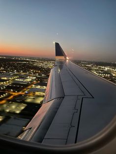 the wing of an airplane flying over a city at night