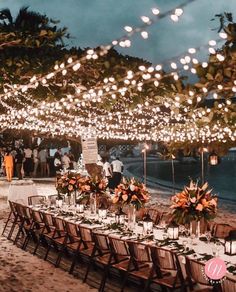 an outdoor dinner setup with lights strung over the tables