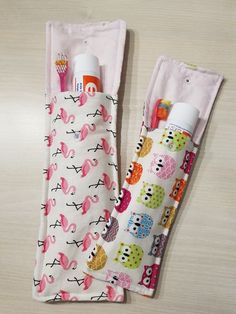 two baby bibs with toothbrushes in them on a table