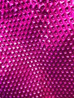 close up view of the surface of a purple plastic material with small holes in it