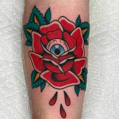 a red rose with an evil eye tattoo on it's left leg and foot