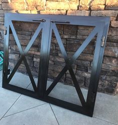 a black metal door sitting next to a brick wall