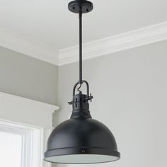 a black light hanging from the ceiling in a room with gray walls and white trim