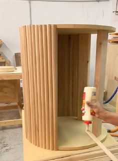 a person is painting a wooden object in a workshop