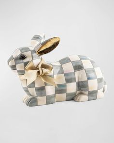 a ceramic rabbit figurine with a gold bow on its head and checkered pattern