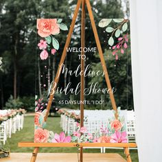 an easel with flowers painted on it for a welcome sign