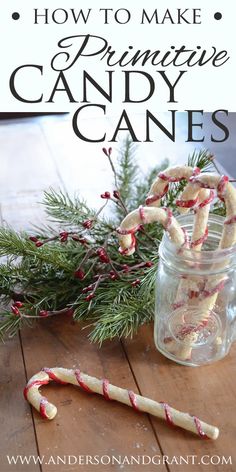 a jar filled with candy canes sitting on top of a wooden table next to a branch