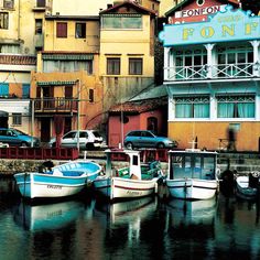 there are many small boats in the water near some buildings and one has a sign that says don't enter