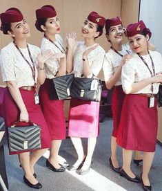 four women in red and white uniforms standing next to each other with their hands together