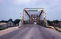 an old metal bridge spanning the width of a road