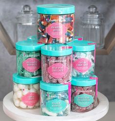 there are many jars with candies in them on the cake plate and one is filled with candy