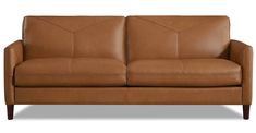 a brown leather couch sitting on top of a white floor